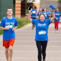 Participants nearing finish line with hands in the air